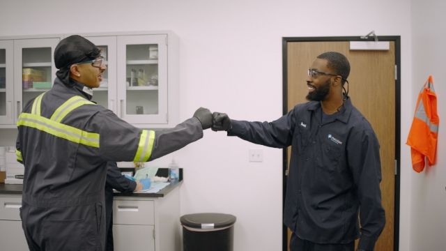 Two workers fist bumping