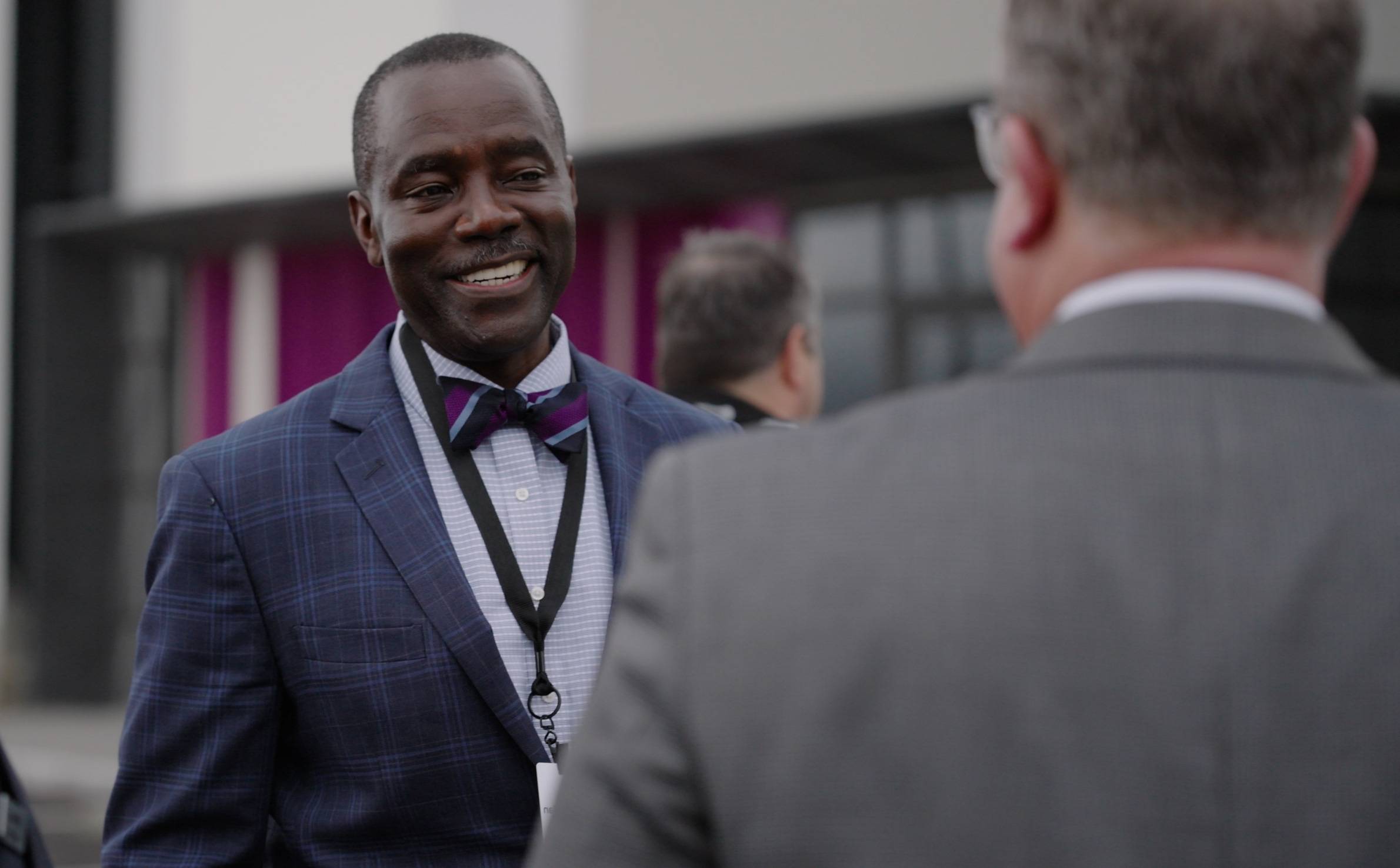 A smiling man wearing a suit